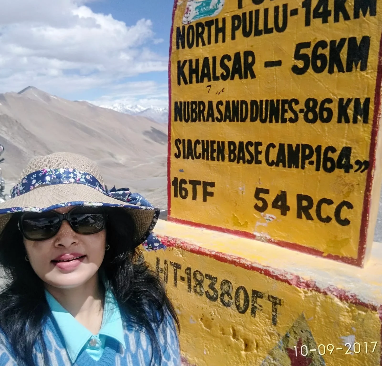 Standing beside the Khardung La Pass signboard in Ladakh.