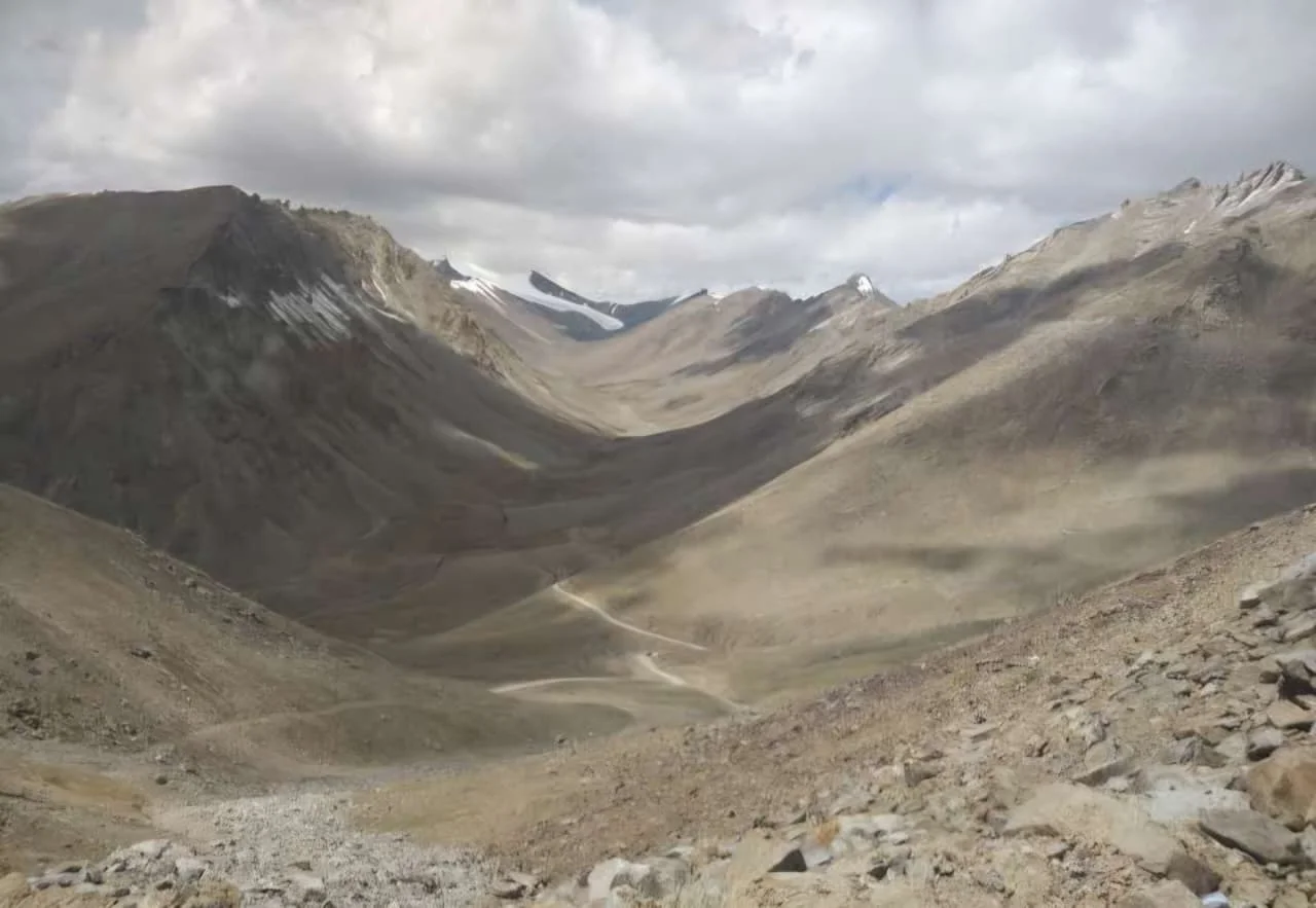 Rocky mountain valley and winding road near Khardung La Pass in Ladakh.