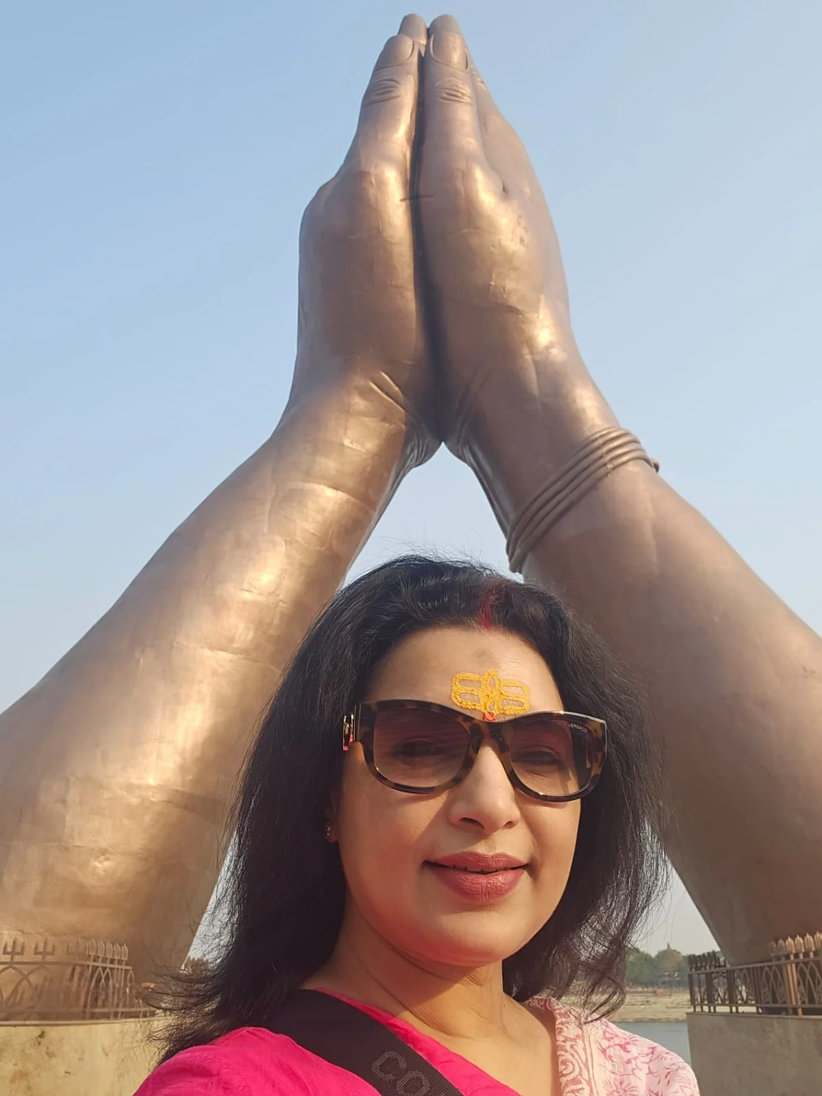 Sleek, modern promenade at Namo Ghat showing giant metal namaste sculptures reflecting in the Ganga river