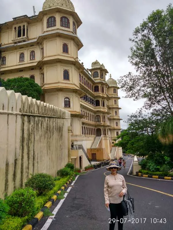 High-resolution editorial photograph of the magnificent Udaipur City Palace complex in Rajasthan with yellow sandstone towers and ornate chhatris