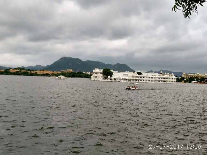 Panoramic view from Jag Mandir Palace floating on Lake Pichola under dramatic Aravalli mountain ranges